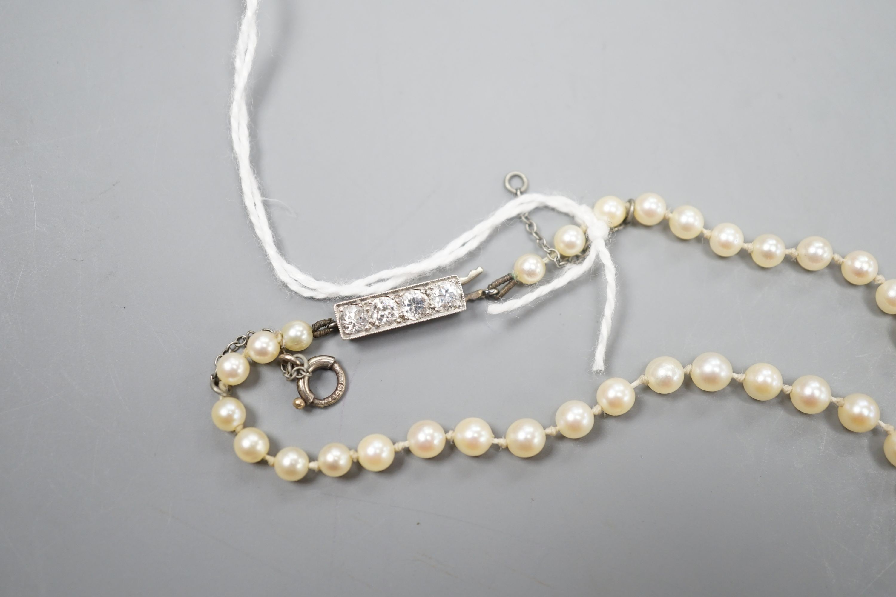 A single strand graduated cultured pearl necklace, with four stone diamond set white metal clasp, 50cm, gross weight 14.4 grams (pearls have not been tested).